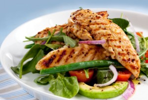 Salad of grilled chicken tenderloins with avocado, tomatoes, red onion, green beans, spinach and arugula.  Delicious healthy eating.