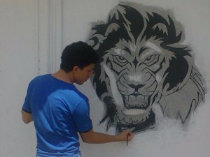 Aquí pinto un león en una pared de mi casa.